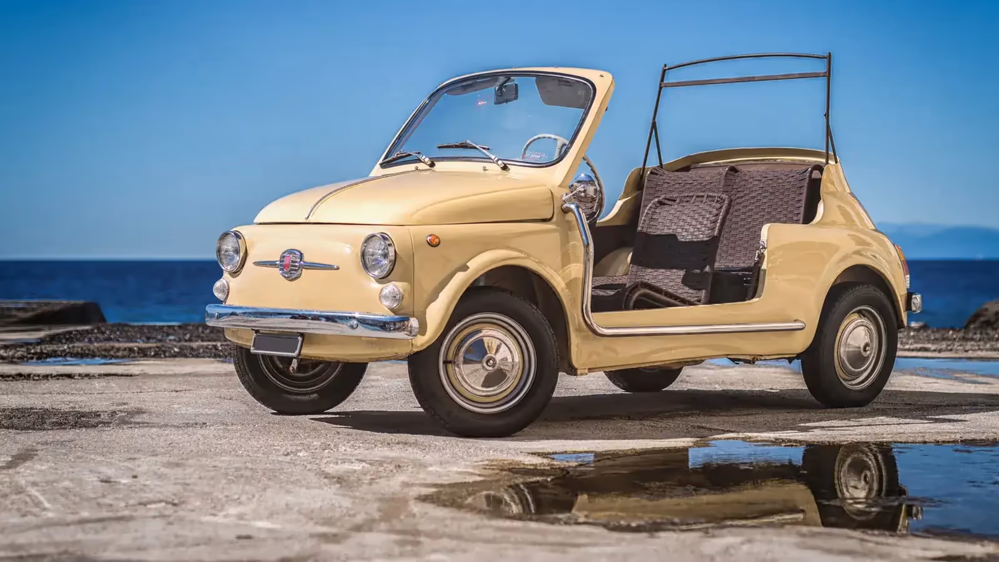 Auto d’epoca color crema fotografata sulla costa